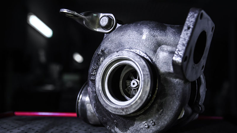 Close-up of a worn turbocharger from a diesel engine.