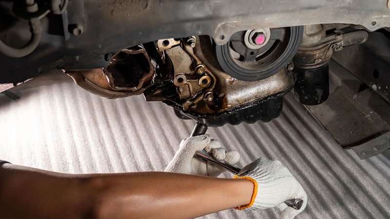 Mechanic repairing an engine oil leak.