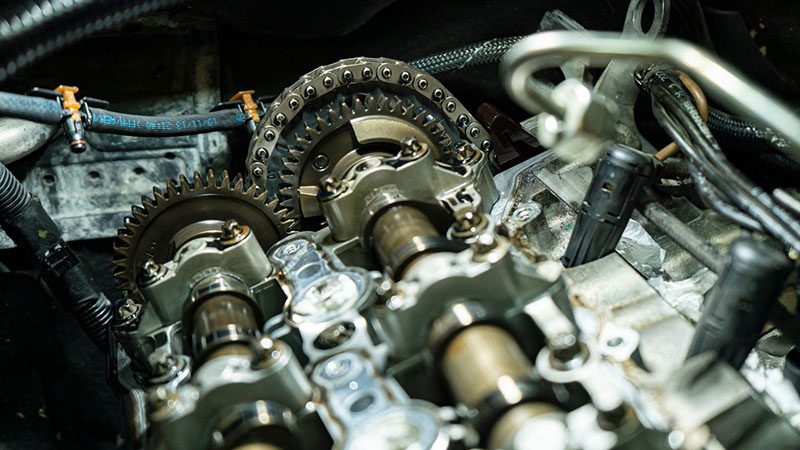 Close-up of a timing chain inside a car engine.