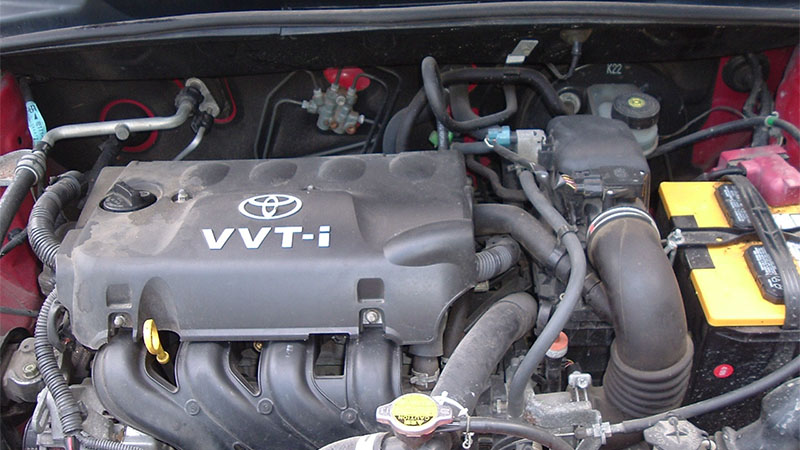 Close-up of a Toyota 1NZ-FE engine under the hood.