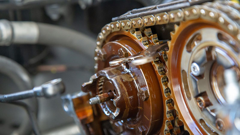 Close-up view of a car timing chain and tensioner system.