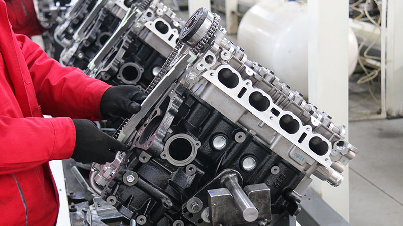 Mechanic working on engine assembly line at Woda Auto’s automotive engine manufacturing factory.