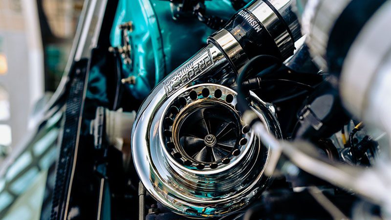 Close-up of a turbocharger on a vehicle engine, highlighting its compact design and metal housing.