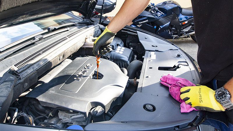 Mechanic performing an oil change on a vehicle.