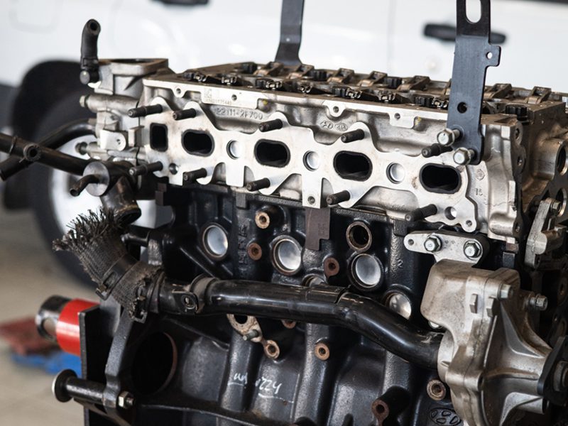 A close-up of a car engine being serviced at an auto repair shop.