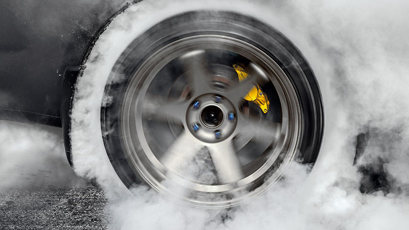 Drag racing car burning rubber during a tire warm-up before the race.