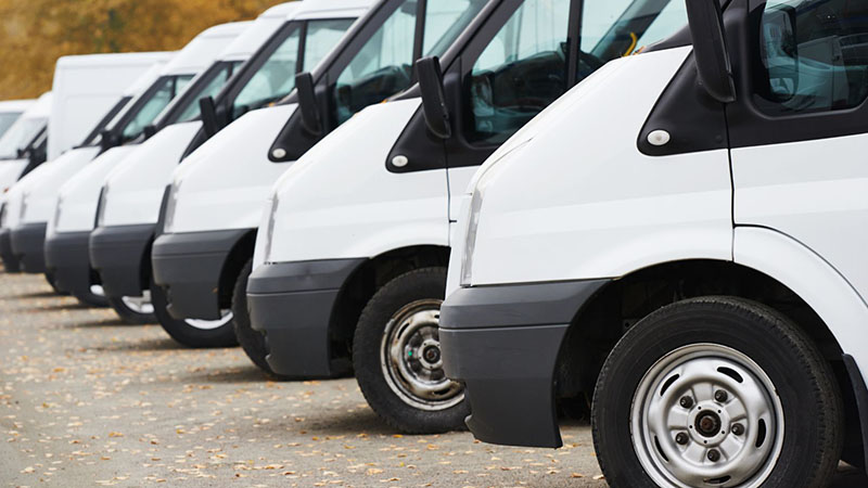 Row of commercial vans commonly powered by Nissan diesel engines.
