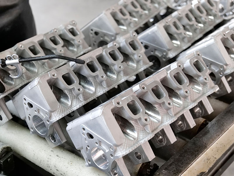 High-quality cylinder heads arranged at Woda Auto’s factory for automotive engine parts production.